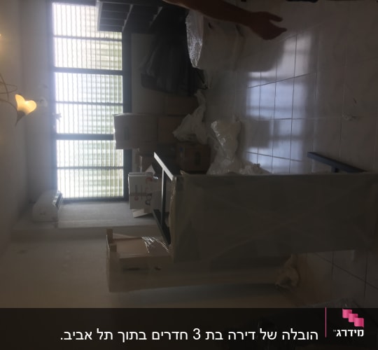 חדר עם קופסאות קרטון ועטיפות פלסטיק למעבר דירה